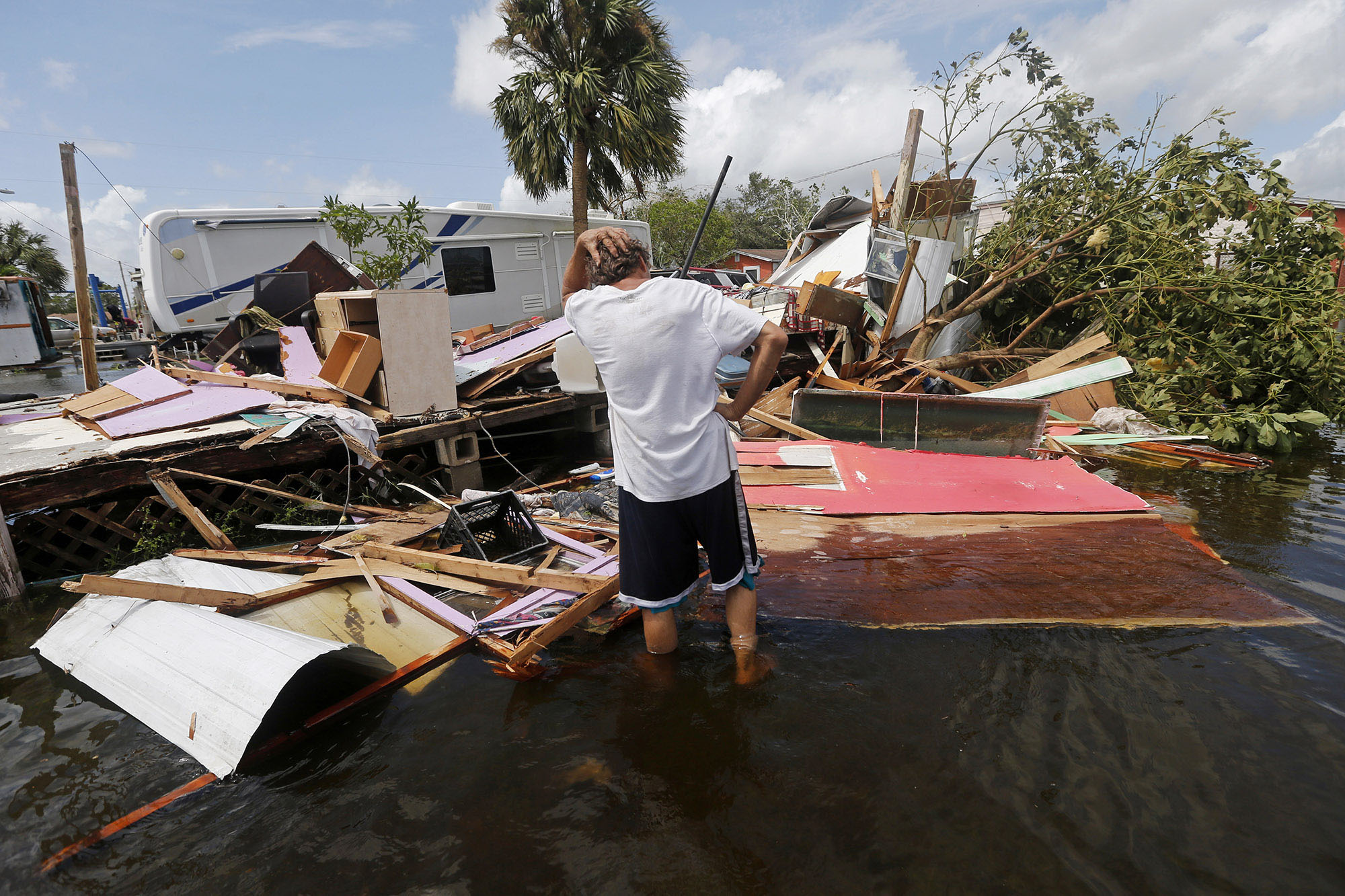 man standing in hurricane wreckage