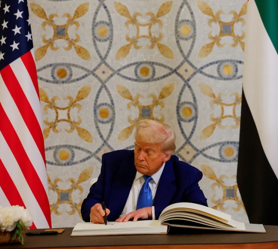 U.S. President Donald Trump signs a guest book next to United Arab Emirates President Sheikh Mohamed bin Zayed Al Nahyan, at Qasr Al Watan, in Abu Dhabi, United Arab Emirates, May 15, 2025.
