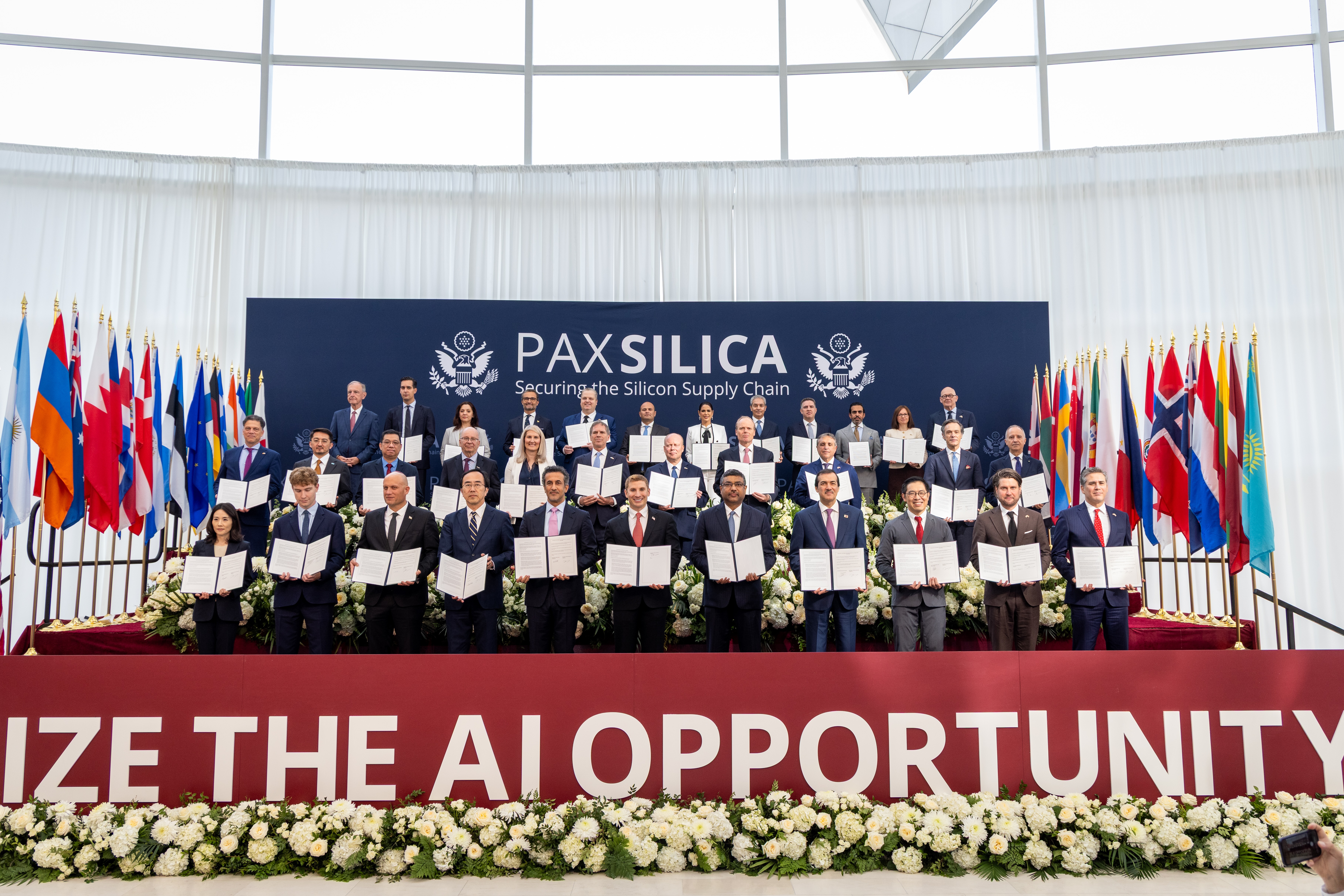 Delegates stand for a photo, each with a signed copy of the joint statement signed by thirty-five nations.