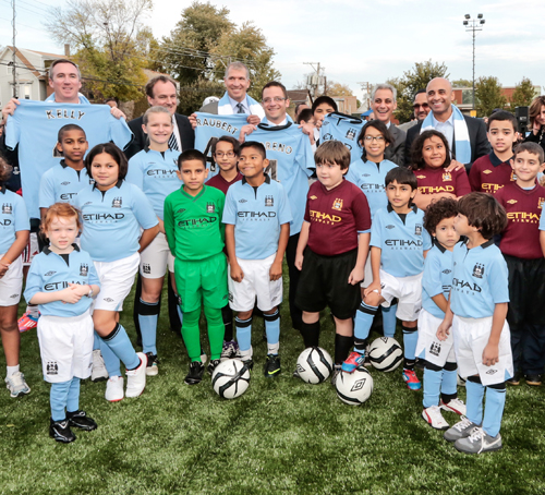 mayor and kids holding up soccer kits