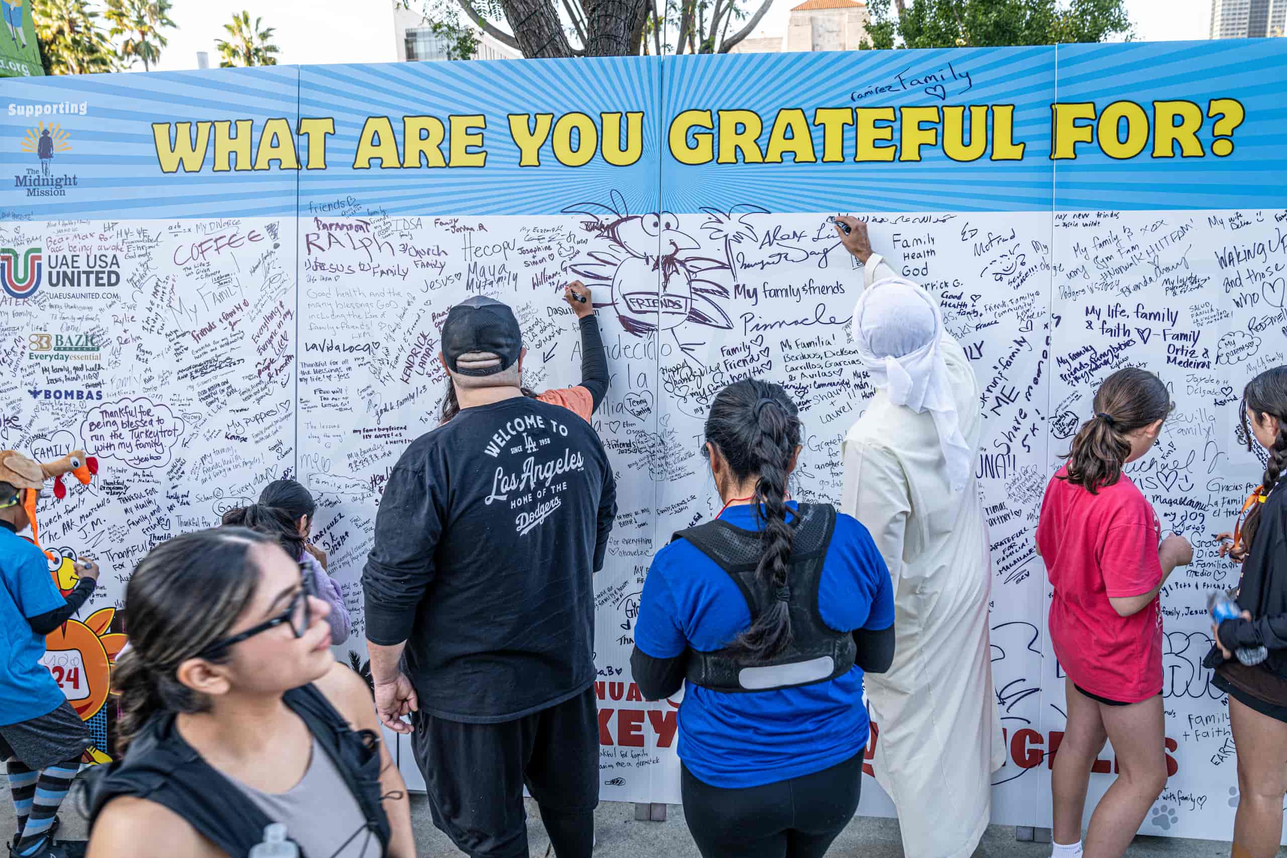 people writing on a wall labeled "what are you grateful for"