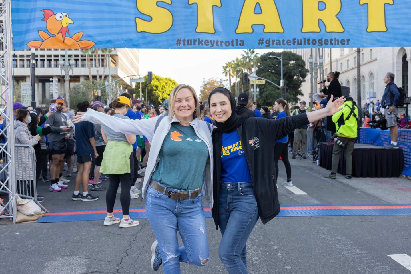 two women posing at the start line of a marathon
