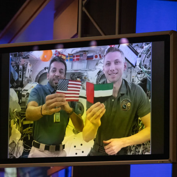 two men holding uae and usa flags